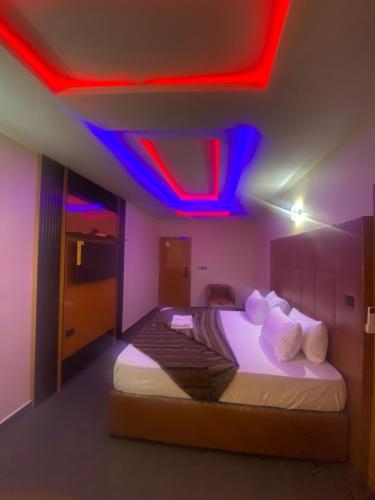 a bedroom with a bed with a red and blue lighting at Beamgate Hotels & Apartments, Abak Rd, Uyo in Uyo
