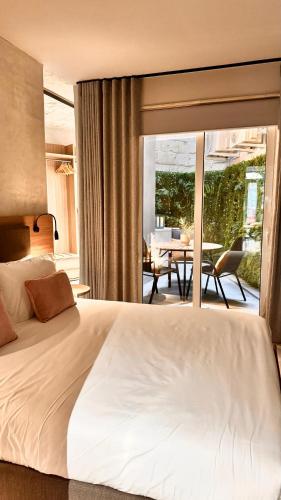 a bedroom with a large white bed and a balcony at Exclusive Retreat off the Sea Front Promenade in Il-Gżira
