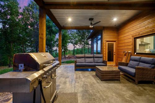 a outdoor kitchen with a grill and two chairs at The Heights - Luxury Cabin with Mountain Views & Hot Tub in Stephens Gap