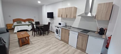 a room with a kitchen and a bedroom with a bed at El Rincón de Perez B in Ajo