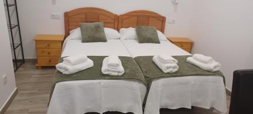 a bedroom with a bed with white towels on it at El Rincón de Perez B in Ajo
