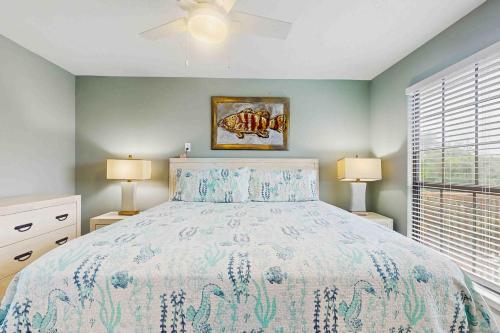 Un dormitorio con una cama y dos lámparas y una ventana. en Sea Shell - Unit A, en Gulf Shores