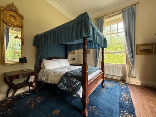 a bedroom with a canopy bed and a blue rug at Shannon River House & Gardens in Limerick