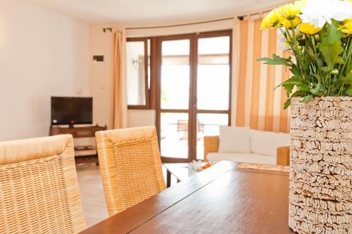 a living room with a table and a vase with flowers at San Marco Villas in Kranevo