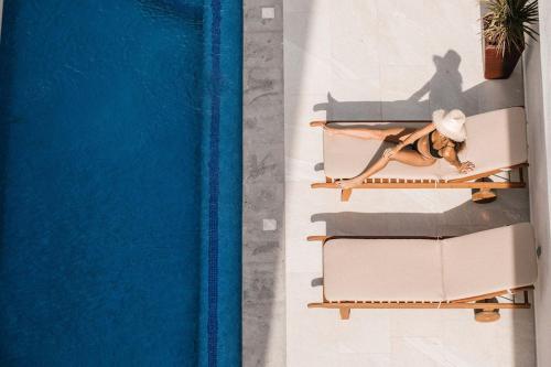 a woman laying on a chair next to a pool at Florence Sayulita in Sayulita