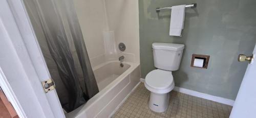 a bathroom with a toilet and a shower at white columns motel in Pine Mountain