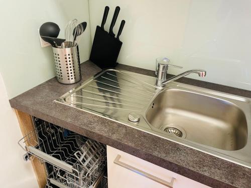a kitchen counter with a sink and a dishwasher at APSTAY City Center I FREE Parking I Self Check-in in Graz