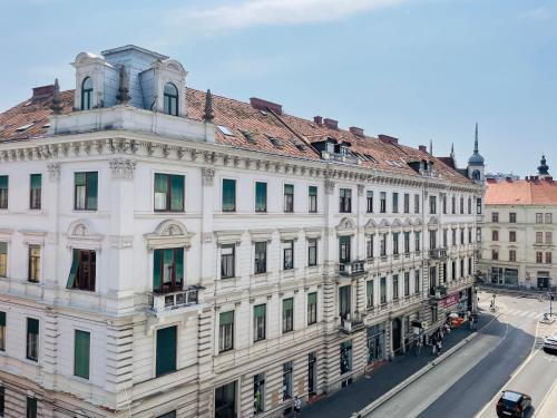 a white building with a clock tower on top of it at APSTAY City Center I FREE Parking I Self Check-in in Graz