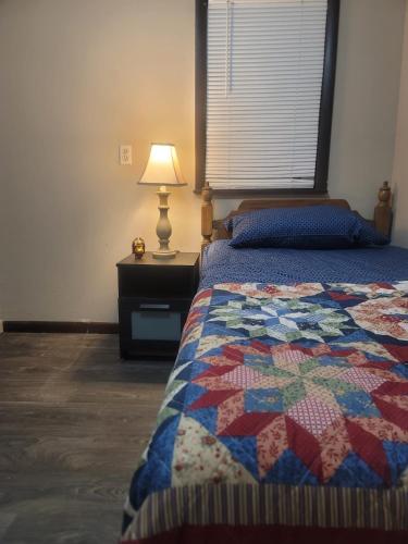 a bedroom with a bed with a quilt on it at Carepoint Residence in Lawnside