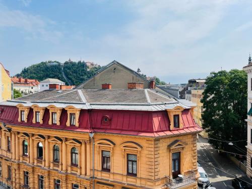 an old building with a red roof in a city at APSTAY City Center I FREE Parking I Self Check-in in Graz