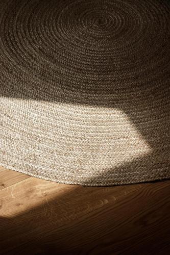 a rug on a wooden floor with a shadow on it at Tide and Timber Luxury Guesthouse in Hermanus