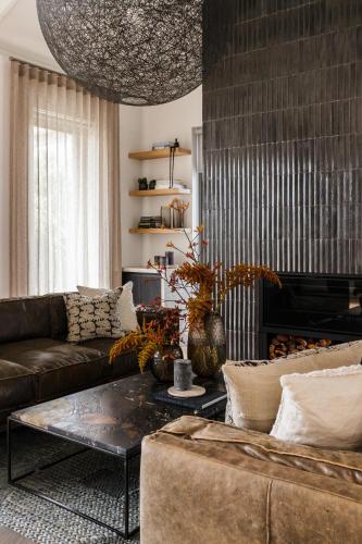 a living room with a couch and a coffee table at Tide and Timber Luxury Guesthouse in Hermanus