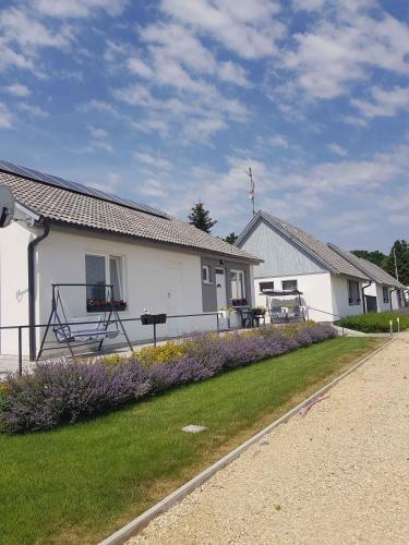 a white house with purple flowers in the yard at Apartments in Bük - Nordtransdanubien 44085 in Bükfürdő