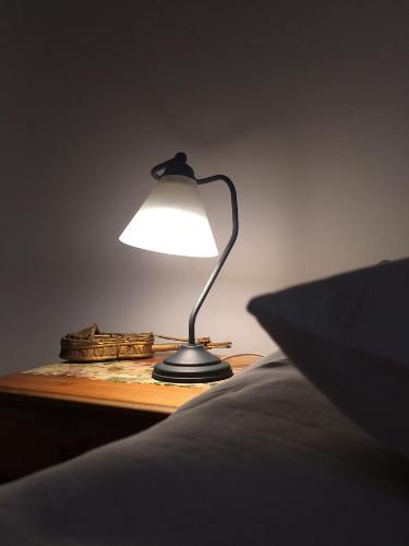 a lamp sitting on a table next to a bed at Restauracja Pensjonat Buda in Krosno