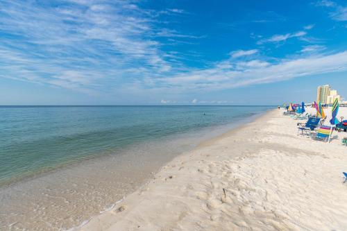 a beach with beach chairs and the ocean on a sunny day at Phoenix II 2151 condo in Romar Beach