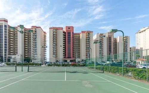 a tennis court in front of some tall buildings at Phoenix II 2151 condo in Romar Beach