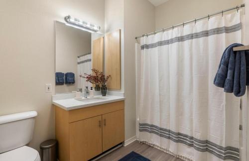 a bathroom with a sink and a shower curtain at The Sunstone - Full Oceanview Right On The Sand in Los Angeles