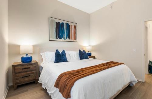 a bedroom with a large white bed with blue pillows at The Sunstone - Full Oceanview Right On The Sand in Los Angeles