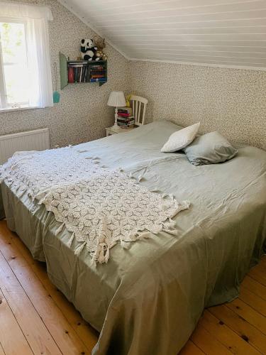 a large bed in a bedroom with a window at Charming 1900S Cottage In Billinge Village in Norrtälje