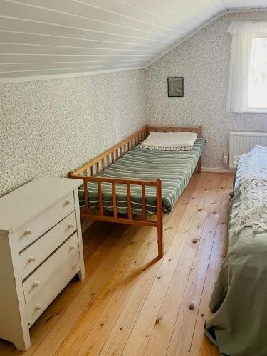 a bedroom with two beds and a wooden floor at Charming 1900S Cottage In Billinge Village in Norrtälje