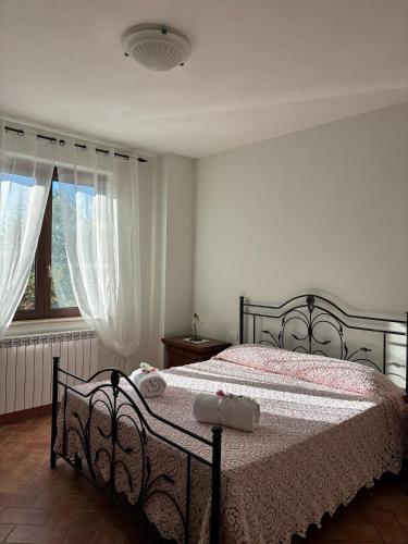 a bedroom with a bed and a window at Casale dei Gelsomini - Country House in Poggio
