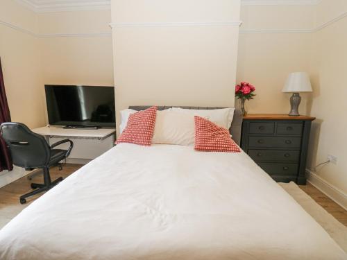 a bedroom with a bed and a desk and a television at St Ronans in Bishop Auckland
