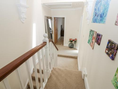 a hallway with a staircase with paintings on the wall at St Ronans in Bishop Auckland