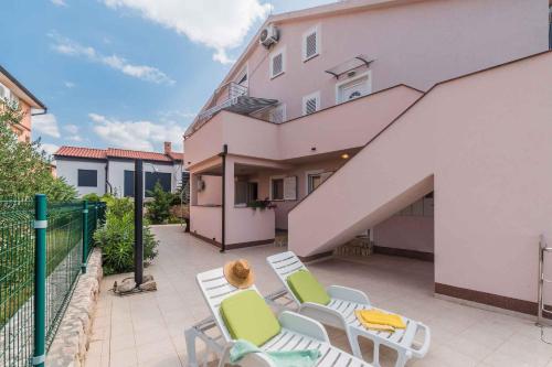 a patio with chairs and a table and a building at Apartments in Klimno - Insel Krk 13574 in Klimno