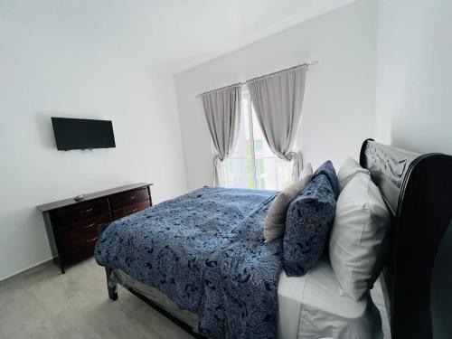 プンタ・カナにあるComfortable 1BDR in Cana Pearl with Lake/Golf Viewのベッドとテレビのある寝室