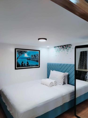 a bedroom with a bed with a picture on the wall at 1A - Cabanatuan City's Best Bed and Breakfast Place in Bantug