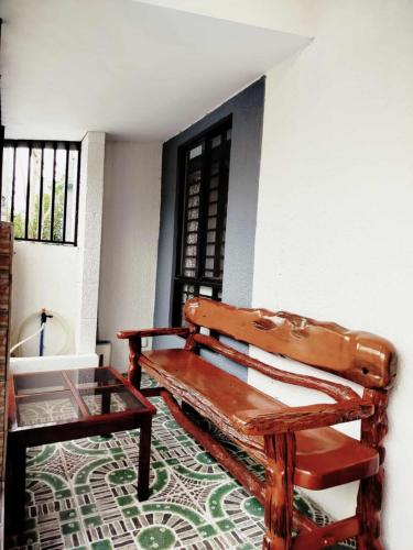 a wooden bench and a table in a room at 1A - Cabanatuan City's Best Bed and Breakfast Place in Bantug