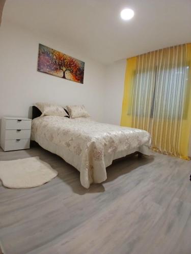 a bedroom with a bed and a painting on the wall at Apartment Sunny in Sarajevo