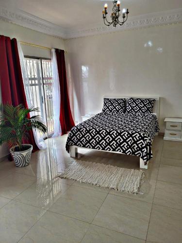 a bedroom with a black and white bed and a plant at Private Room in Luxury Villa Secure Gated Area, Dakar in Pikine