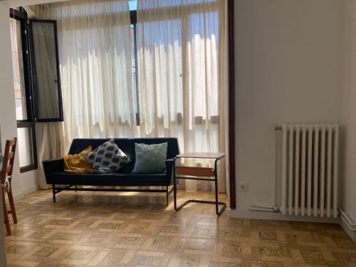 a living room with a blue couch and a table at Caliu Tremp in Tremp
