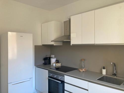 a kitchen with white cabinets and a white refrigerator at Caliu Tremp in Tremp