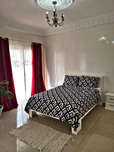a bedroom with a bed with a black and white comforter at Private Room in Luxury Villa Secure Gated Area, Dakar in Pikine