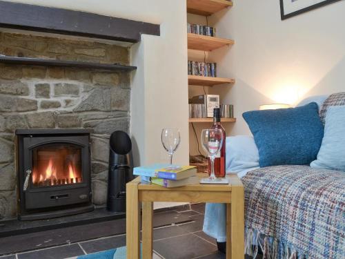 Una sala de estar con un sofá y una chimenea. en Isallt, en Nantlle