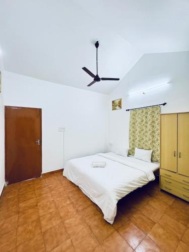 a white bedroom with a bed and a ceiling fan at Tony apartment baga in Baga