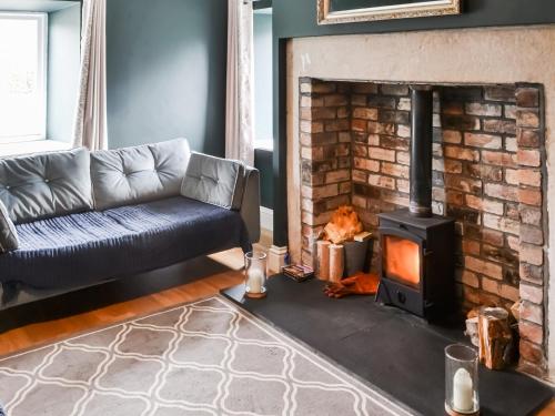 a living room with a couch and a fireplace at Prospect Cottage in Catton