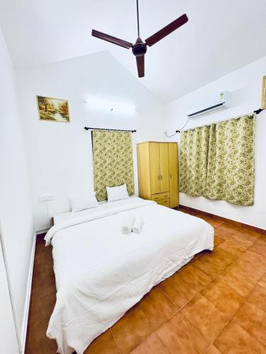 a bedroom with a white bed and a ceiling fan at Tony apartment baga in Baga