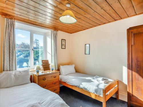a bedroom with two beds and a window at Prosperous Villa in Puncknowle