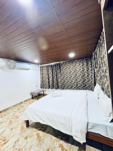 a bedroom with a large bed with a wooden ceiling at Tony apartment baga in Baga