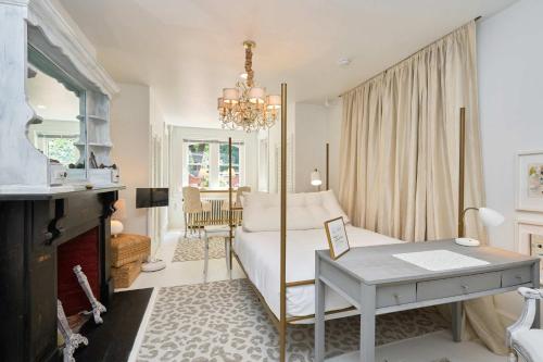 a bedroom with a bed with a desk and a fireplace at Private DC Retreat on Iconic East Capitol St in Washington, D.C.