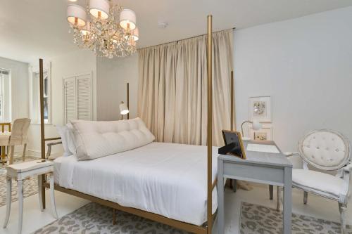 a bedroom with a bed and a desk and a chandelier at Private DC Retreat on Iconic East Capitol St in Washington, D.C.