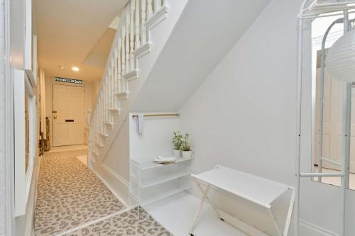 a hallway with white stairs and a white bench at Private DC Retreat on Iconic East Capitol St in Washington, D.C.