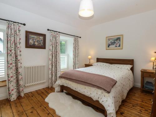 a bedroom with a bed and two windows at Chandos in Dolwyddelan
