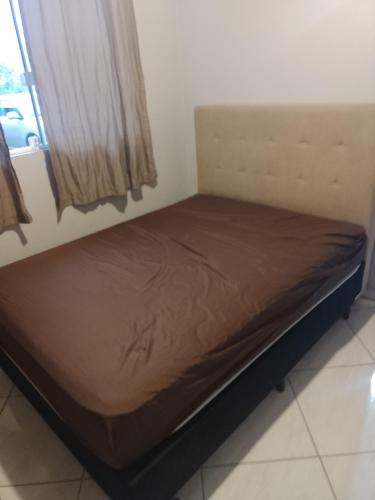 a small bed in a room with a window at Recanto da vila in Garopaba