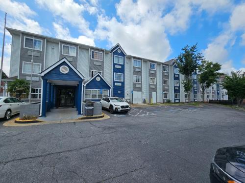 a large building with cars parked in a parking lot at Microtel Inn by Wyndham Atlanta Airport in Atlanta