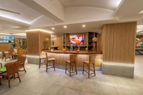 a bar in a hotel lobby with chairs and tables at Copacabana Beach Hotel Acapulco in Acapulco