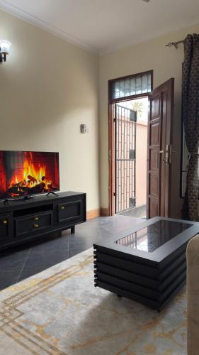 a living room with a fireplace and a couch at Grace Haven Airport Day-Use & Overnight Stays Hotel in Dar es Salaam
